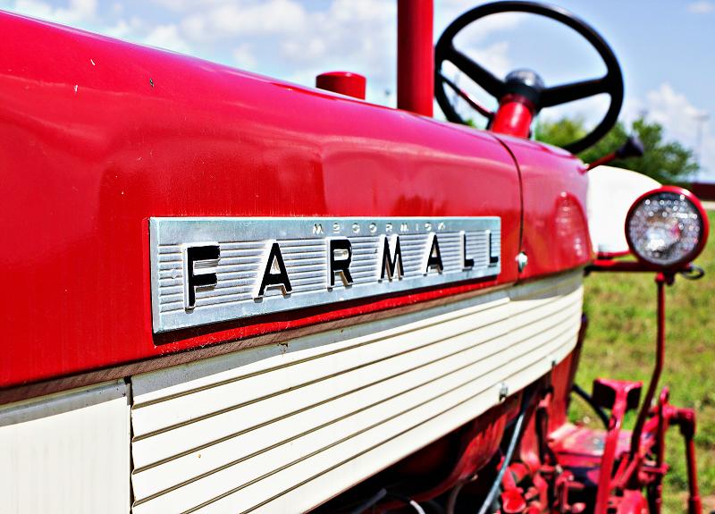 Close-up view of Harvest Green's shiny red Farmall tractor in the field.