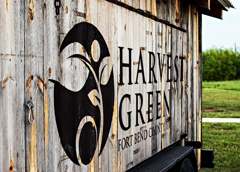 A barn door painted with the text Harvest Green, Fort Bend Community.
