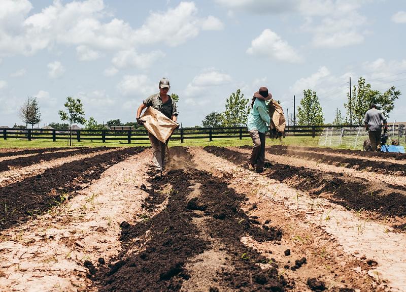Farmers and residents  adding new soil for a Fort Bend community farm.