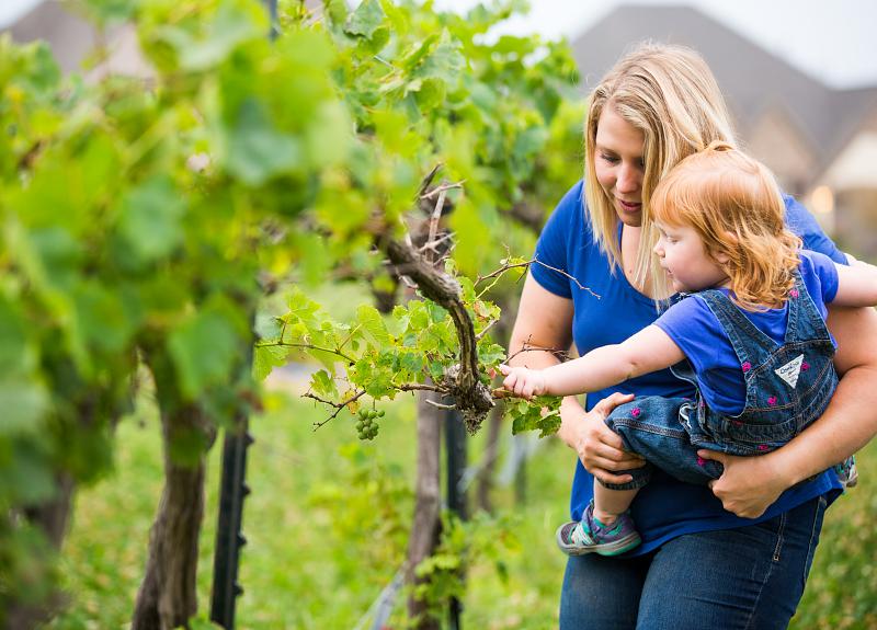 A woman and child in Harvest Green's onsite vineyard in Richmond, TX.