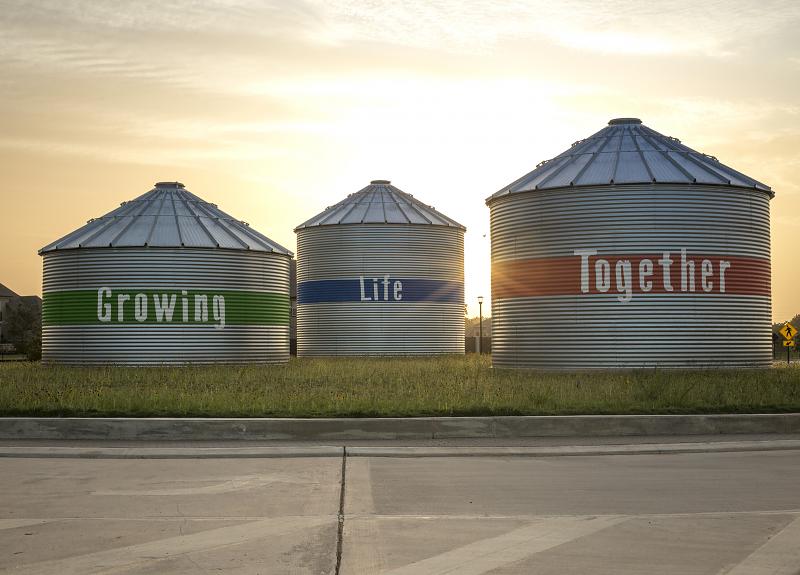 A community photo of Harvest Green's iconic silos, saying Growing Life Together.