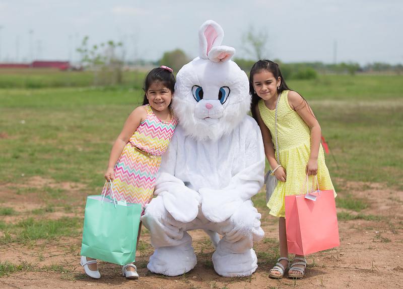Children pose with an Easter bunny during a Harvest Green resident event.