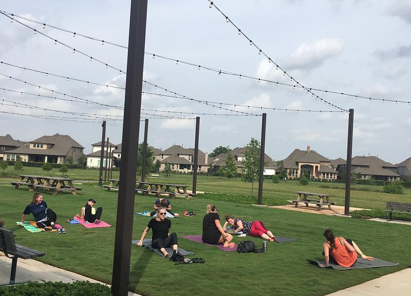 Harvest Green residents enjoy a yoga class on The Farmhouse's event lawn.