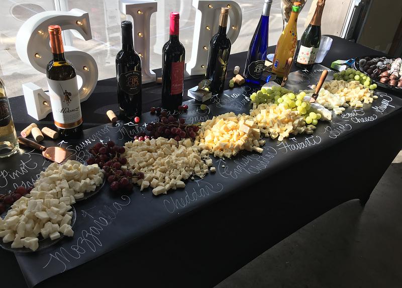 Spread of wine, grapes, and cheese from a Harvest Green resident event.