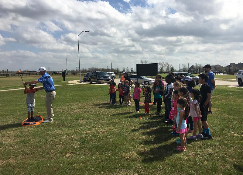 Children gather to learn  golf swing during a Harvest Green resident event.