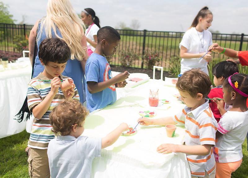 Children paint outdoors during a Harvest Green resident event in Fort Bend.