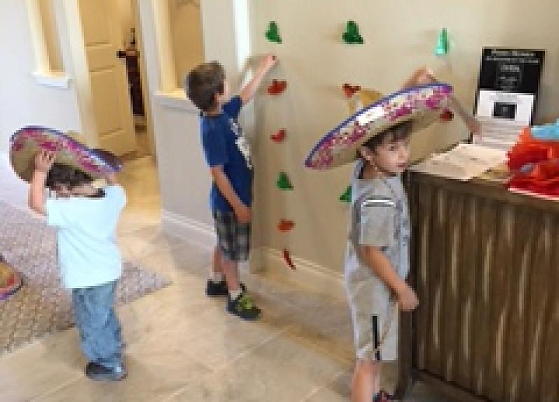 Children explore Cinco de Mayo fiesta decorations in Fort Bend model home.